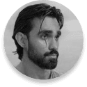 Black-and-white portrait of a man with swept-back hair and a beard