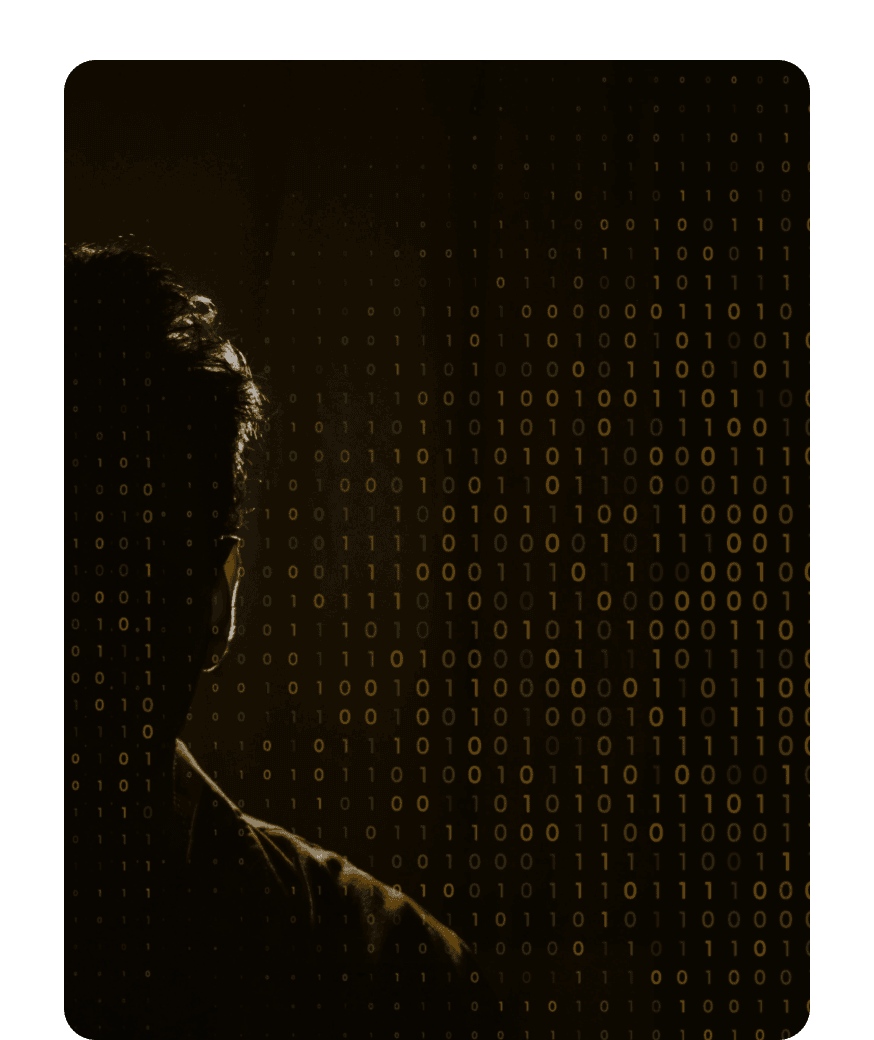 Silhouette of a man in shadow facing a wall of glowing gold binary code